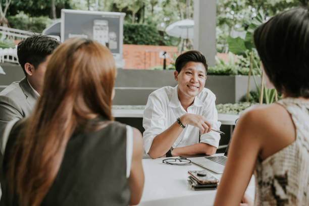 Smiling face while discussing work with marketing team are  business meeting at outdoor area at their office, talking and discussing on their project together.
