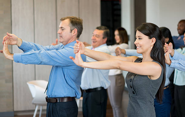 Latin American business group at the office making a work pause and stretching